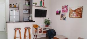 a room with two stools and a tv on a wall at Praia de Palmas Ville in Governador Celso Ramos