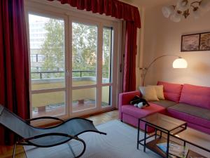 sala de estar con sofá púrpura y ventana en Family Buda Apartment, en Budapest