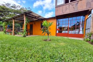 an orange building with a palm tree in the yard at Sweet little cottage at Lake La Laguna in San Pedro La Laguna