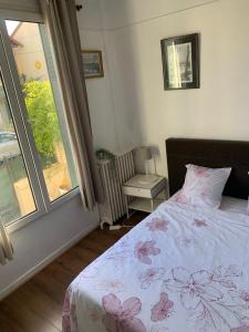 um quarto com uma cama e uma janela em GRAND APPARTEMENT AVEC TERRASSE & JARDIN A 5 minutes de PARIS em Cachan