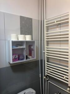 a bathroom with a toilet and a shelf with towels at Adrian Home Libra in Ploieşti +28 photos