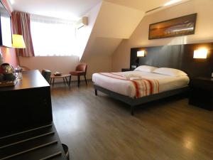 a hotel room with a bed and a desk at Hotel Be Guest Limoges Sud - Complexe BG in Limoges