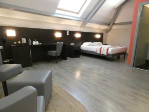 Cette chambre comprend un lit et un bureau. dans l'établissement Hotel Be Guest Limoges Sud - Complexe BG, à Limoges