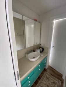 uma casa de banho com um lavatório e um espelho em Apto alto padrão em Florianópolis em Florianópolis
