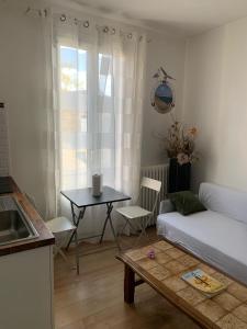 ein Wohnzimmer mit Tisch und Couch in der Unterkunft 3 Hebergements à 5 minutes de Paris et 30 MN Stade de France in Cachan