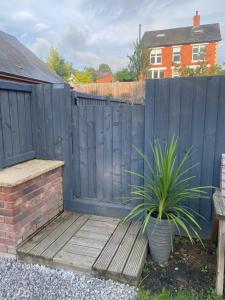 a wooden bench next to a fence with a plant at Dave & Kelz Deluxe king size studio room in Builth Wells