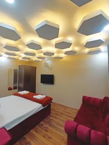 a room with a bed and a couch and a ceiling at Farmhouse - A Luxury Living in Srinagar