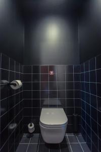 ein Bad mit WC und blau gefliesten Wänden in der Unterkunft JOST Hôtel Le Havre Centre Gare in Le Havre