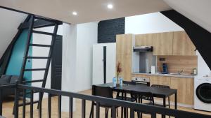 uma cozinha e sala de jantar com uma mesa e uma escada em *Le Cristal Doré*Wifi*Parking em Lens