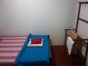 a bedroom with a blue bed with a red pillow at LLT budget room WILPATTU in Nochchiyagama