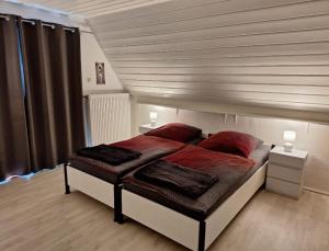 ein Schlafzimmer mit einem Bett mit roten Kissen in der Unterkunft Parva Domus in Xanten