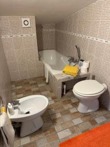 łazienka z toaletą, umywalką i wanną w obiekcie Suite Tania w mieście Fregene