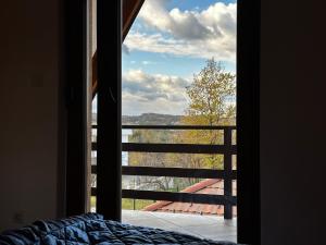 ein Schlafzimmer mit einem Fenster mit Blick auf einen Balkon in der Unterkunft VIKENDICA TOJA - Brcko in Brčko