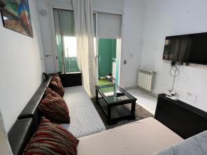 a living room with a couch and a tv at My Second Home in Tunis