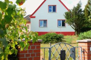 a white house with a red roof at Ferienhaus zum Glück, mit Pool und Kamin in Gerswalde