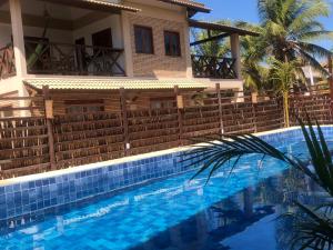 a villa with a swimming pool in front of a house at BEACH HOUSE - Apartment 2 - com cozinha - with kitchen in Barra Grande