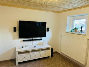 a living room with a flat screen tv on the wall at Pool, Sauna und Blick ins Grüne in Lutherstadt Wittenberg