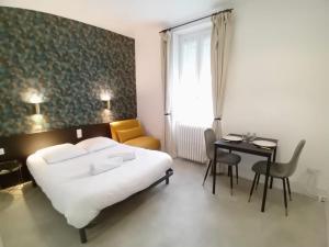um quarto com uma cama, uma mesa e uma cadeira em Guest Home location em Néris-les-Bains