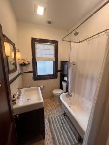 La salle de bains est pourvue d'un lavabo, d'une baignoire et de toilettes. dans l'établissement 5 BR Downtown Savannah GA, à Savannah