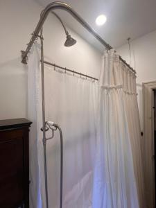 a shower rod with a white shower curtain at 5 BR Downtown Savannah GA in Savannah