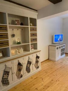 een woonkamer met een groot wit entertainmentcentrum bij FachwerkLiebe in Quedlinburg