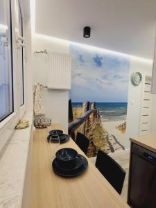 a dining room with a table with a view of the beach at Apartament Nad Klifem SEA VIEW in Gdynia