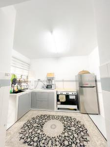 a kitchen with white appliances and a rug on the floor at Homestay Dsunway in Petaling Jaya