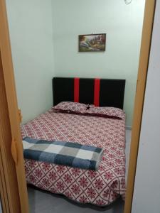 - une chambre avec un lit doté d'une couette rouge et noire dans l'établissement Hana homestay D Yan Bedroom3, à Yan