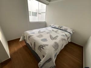 1 dormitorio con cama con edredón y ventana en Apartment 4 Rent - Av San Borja Sur Cdra 4, en Lima