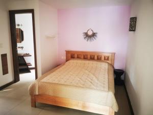 1 dormitorio con 1 cama y reloj en la pared en Casa del Dodo Villa de luxe avec piscine, en Rivière Noire