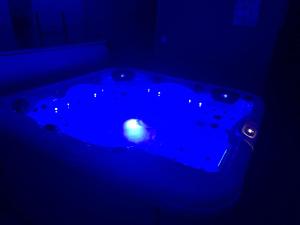 a blue bath tub in a dark room at Chambre privative avec spa in Louplande