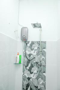 a shower in a bathroom with a plant pattern at Homestay Dsunway in Petaling Jaya