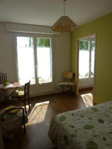 um quarto com uma cama, uma mesa e cadeiras em Chambres d'hôtes : La Isla Bonita em L'Ile-Bouchard