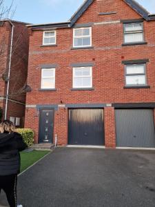 a woman walking in front of a brick house at Royal house in Ilkeston