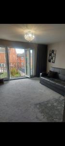 a large living room with a couch and a chandelier at Royal house in Ilkeston