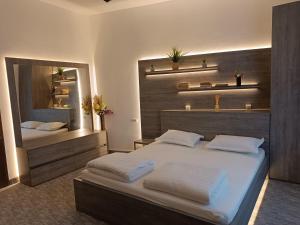 Un dormitorio con una cama grande y un espejo. en Apartament ultracentral, en Oradea