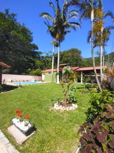 a yard with palm trees and a swimming pool at LagoMar Hostel in Florianópolis