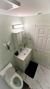 a white bathroom with a toilet and a sink at Entire house 3 min Drive to beach in Eastern Passage