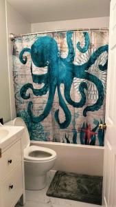 an octopus shower curtain in a bathroom with a toilet at Entire house 3 min Drive to beach in Eastern Passage