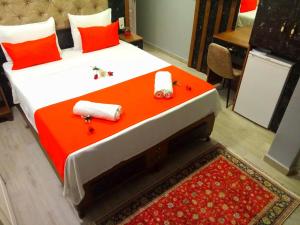 a bedroom with a large bed with red pillows and candles at Roomsin Sultanahmet in Istanbul