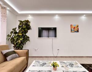 uma sala de estar com um sofá e uma televisão na parede em Villa Max em Sarajevo