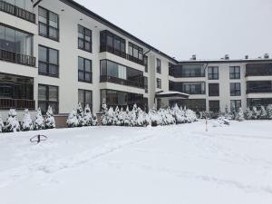 ein großes Gebäude mit Schnee davor in der Unterkunft Apartman Relax Bjelašnica in Trnovo