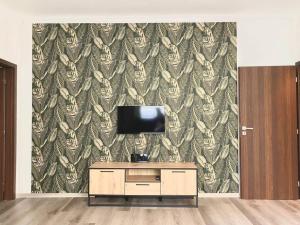 a living room with a tv and a wall with a wallpaper at Apartment 1 in the Bank House in Kutná Hora