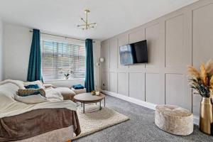 a living room with a bed and a tv at 3BD Retreat Boothstown Manchester in Ellenbrook