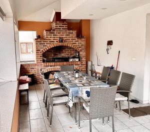 a dining room with a table and a brick fireplace at Villa Max in Sarajevo