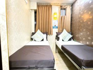 twee bedden in een kleine kamer met gordijnen bij New International Guest House in Hong Kong