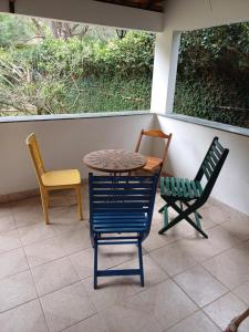 two chairs and a table and two chairs on a porch at Chácara Sensorial Nova Friburgo RJ in Nova Friburgo