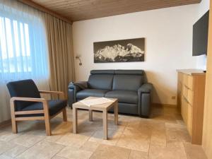 ein Wohnzimmer mit einem Sofa und einem Stuhl in der Unterkunft Appartement Fischer in Sankt Johann in Tirol