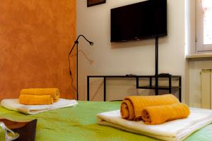 Zimmer mit 2 Handtüchern und einem TV auf dem Bett in der Unterkunft ZenHouse - Nel cuore del centro storico di Torino in Turin