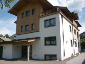 a large white house with a wooden roof at Ferienwohnung Victoria in Brixen im Thale
